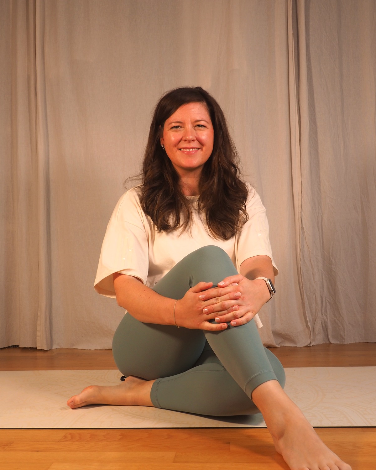 Steffi, Pilates-Trainerin bei Nusa Pilates, ruhig lächelnd auf der Matte